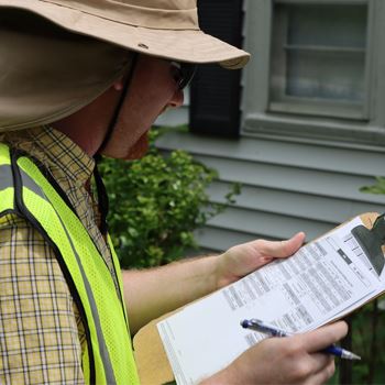 Appraiser writing notes on a clipboard